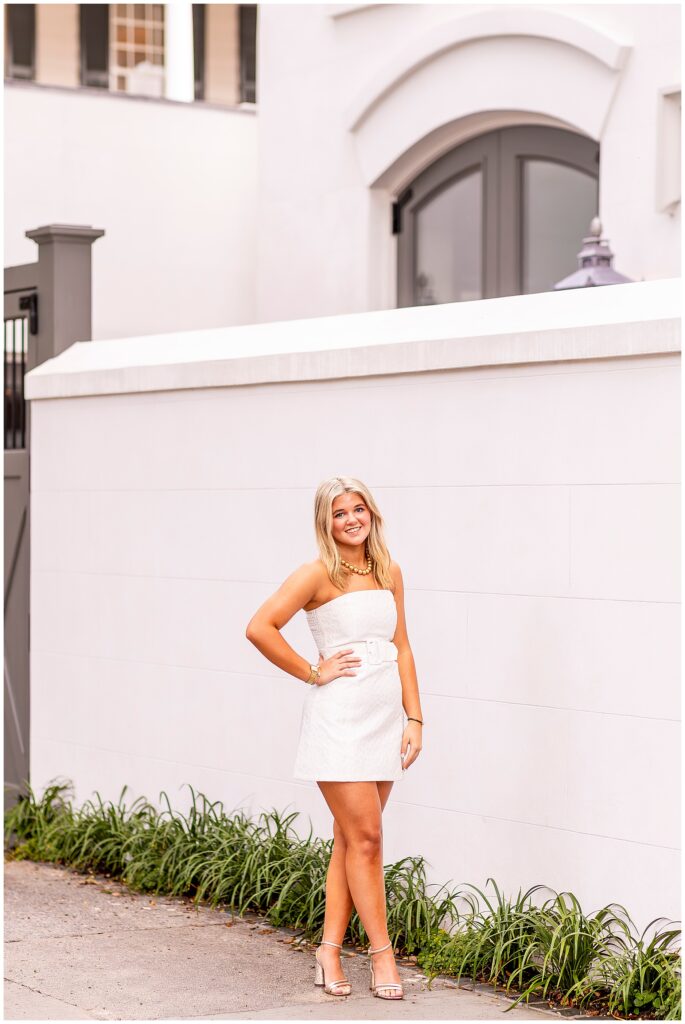 Philip Simmons high school senior in a white dress smiling during her sunrise senior portraits on Meeting Street in Downtown Charleston SC.
