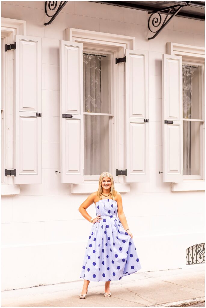 Philip Simmons senior girl in a blue polka-dot dress twirling on Tradd Street during her Downtown Charleston senior session.