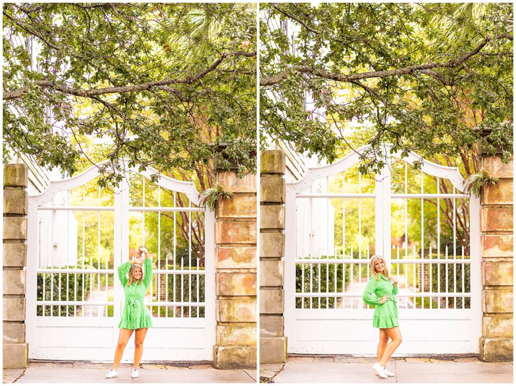 Downtown Charleston senior portraits featuring a stylish senior posing in a green dress in front of a white gate on Meeting Street.