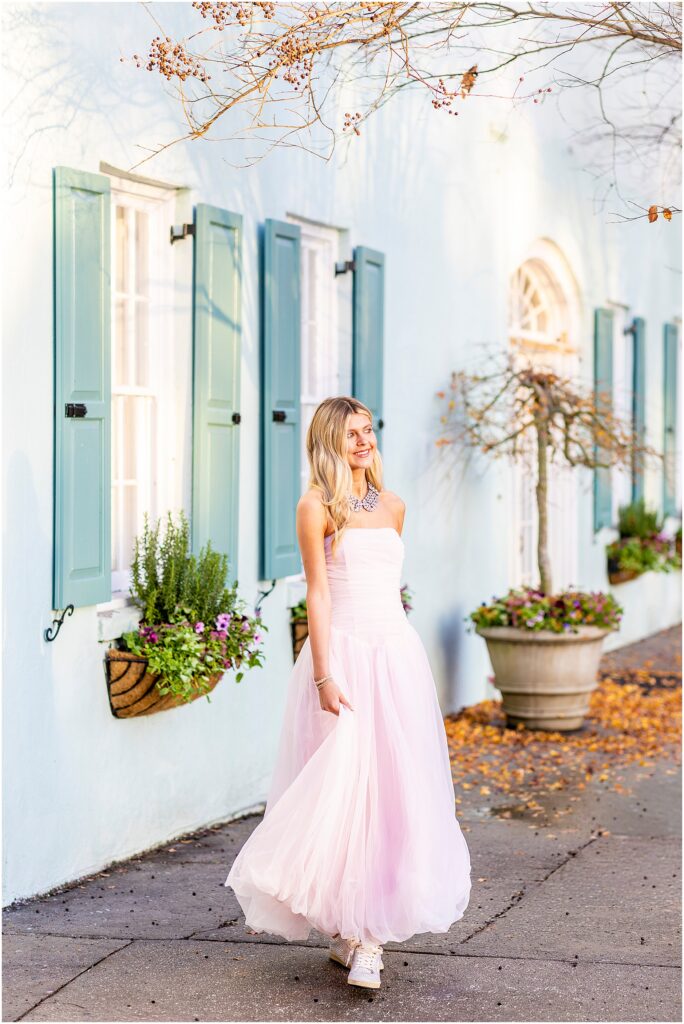 Bella smiling in soft morning light during her Charleston senior session on Rainbow Row.