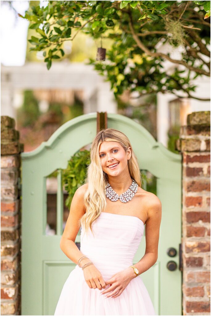 Bella twirling playfully in her dress on Tradd Street during her senior portraits.