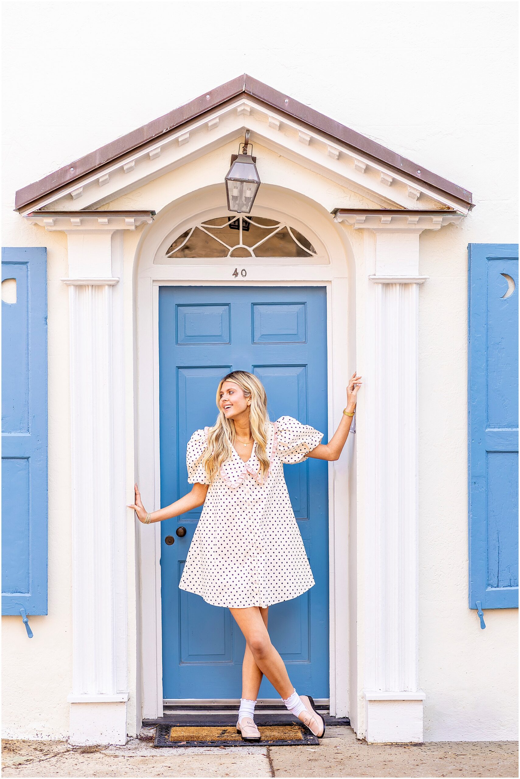 Bella smiling in soft morning light during her Charleston senior session in front of a historic Tradd Street house.