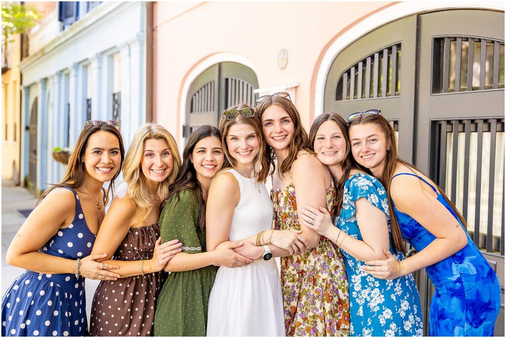 Charleston bachelorette photoshoot with six bridesmaids in light sundresses and bride in white