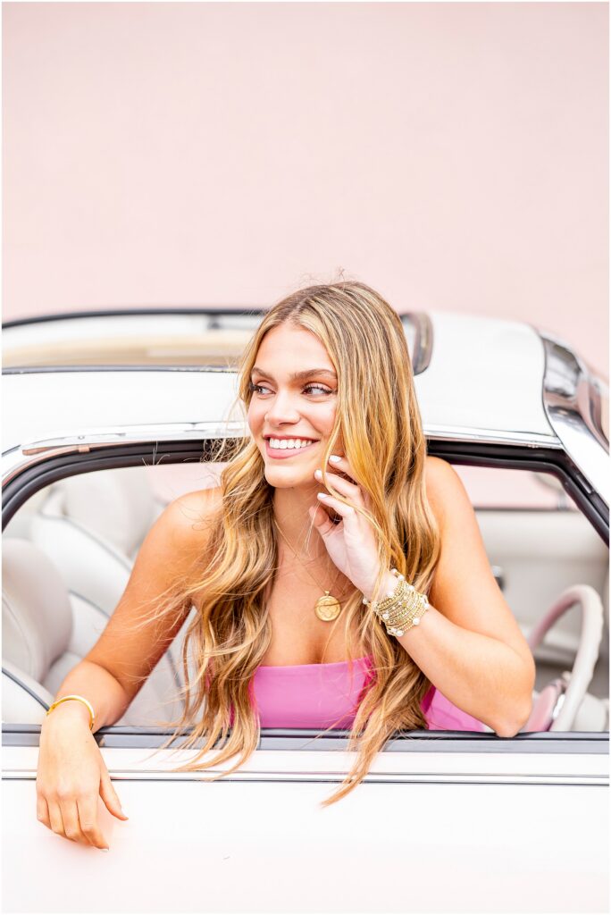 High school senior posing outside the driver's seat of The Pink Figgy