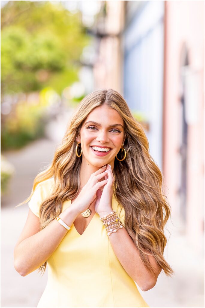 Charleston senior portraits with pastel buildings and morning light at Rainbow Row