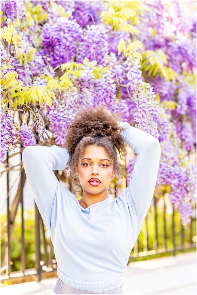 Elegant spring senior photos with purple wisteria flowers in Charleston