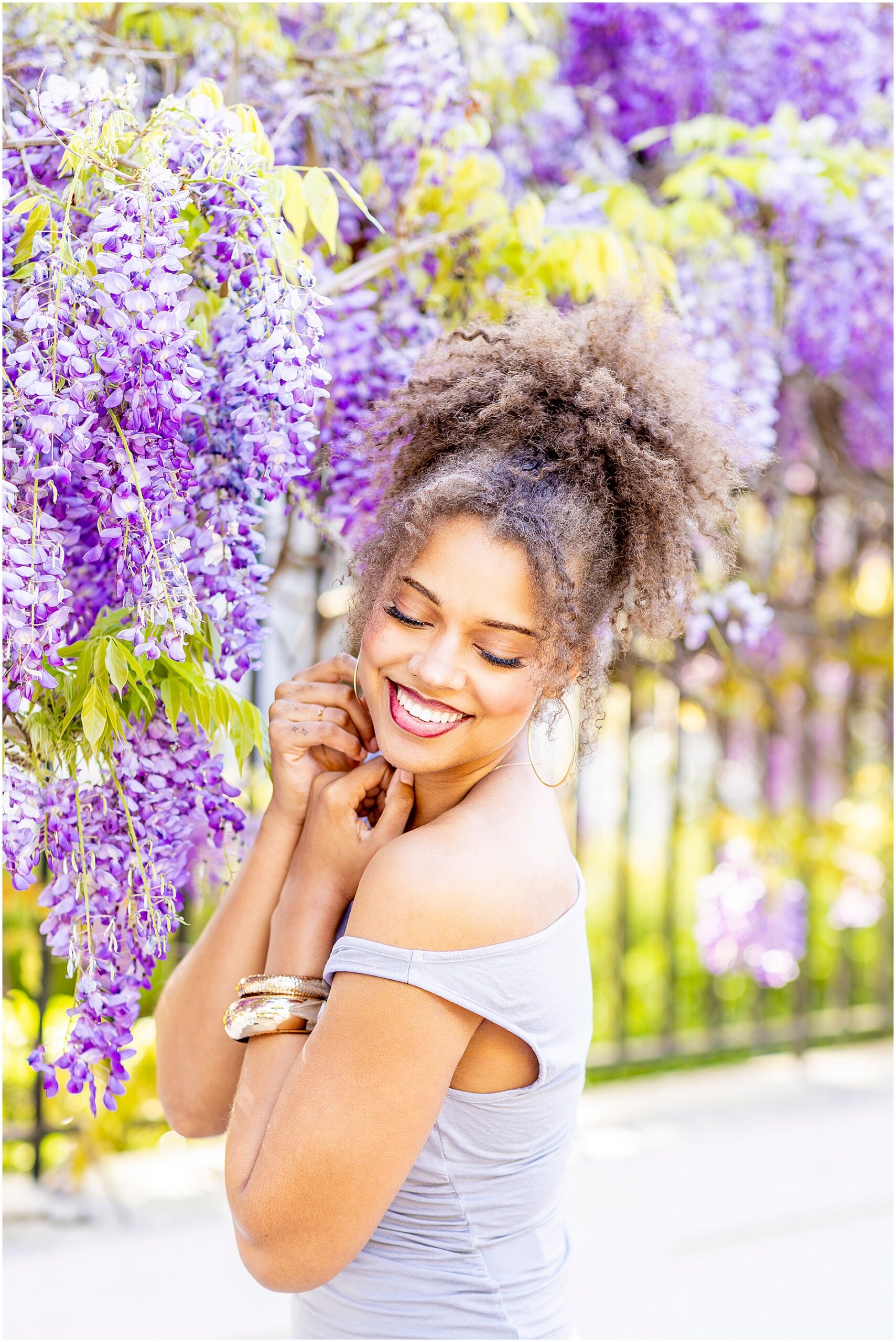 Dreamy senior photoshoot under blooming wisteria in Charleston during spring