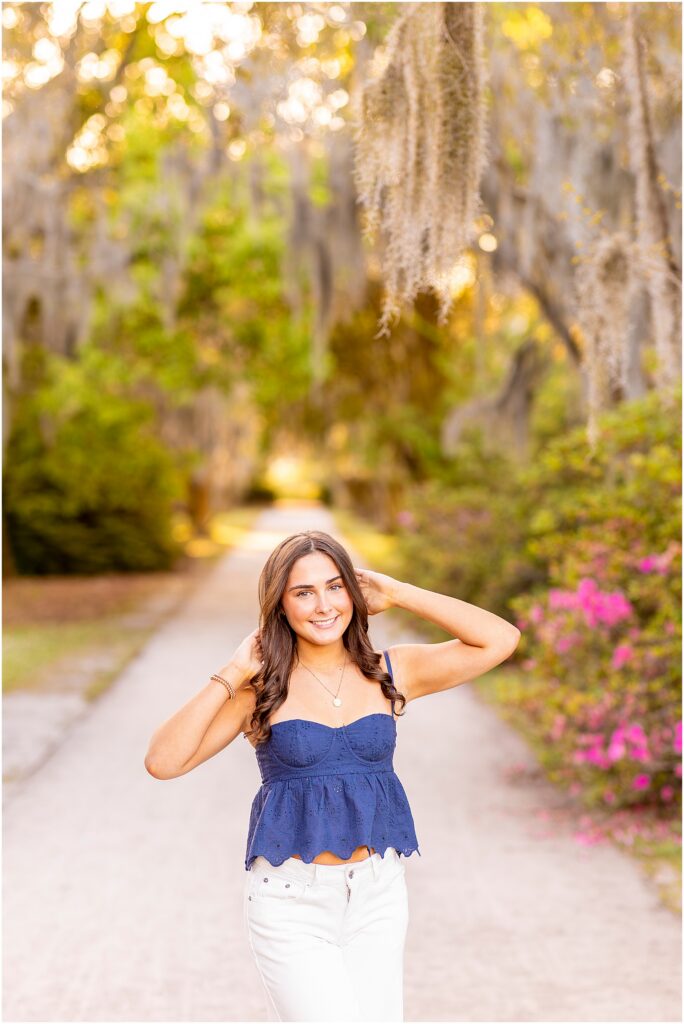 Senior girl posing for her photos in Hampton Park, Charleston, with her hands in her hair