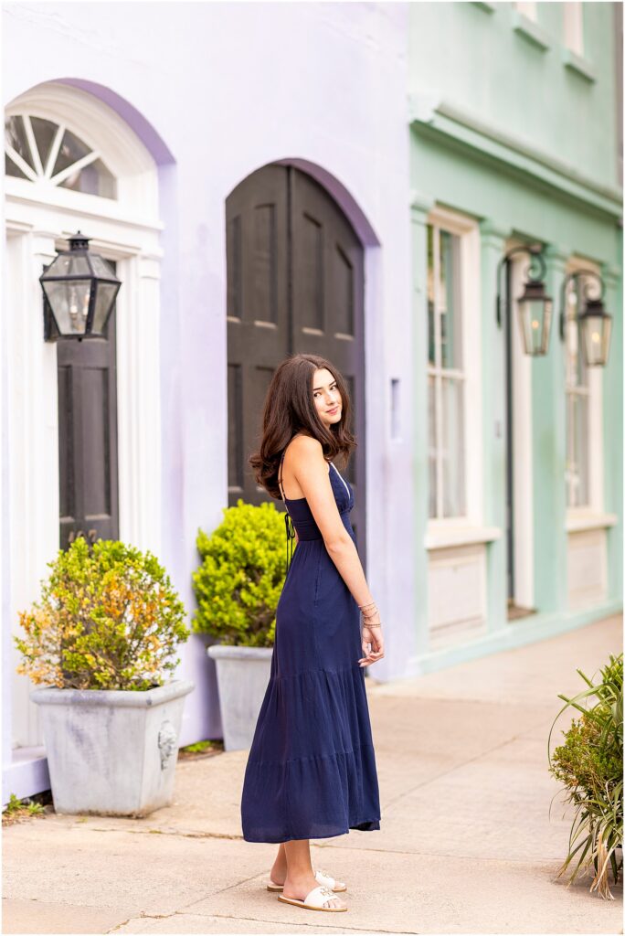 Charleston senior photos at Rainbow Row with pastel historic homes in downtown Charleston