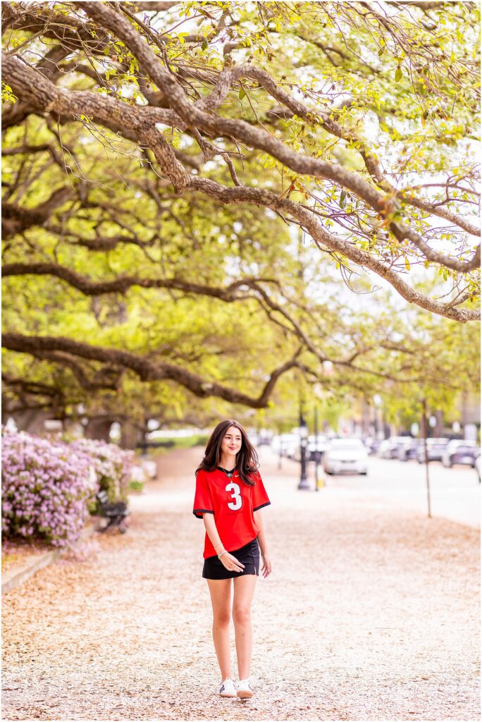 High school senior walking through Charleston park during golden hour session