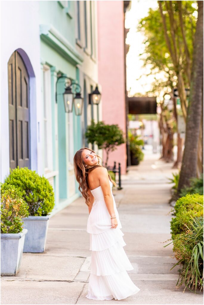 High school senior twirling in her dress on Rainbow Row for her senior photos