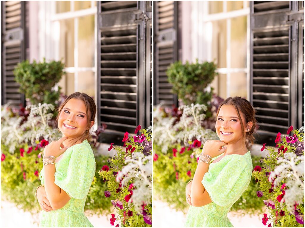 Cute and fun senior portraits in a bright green dress in front of full window boxes on Rainbow Row in downtown Charleston, South Carolina
