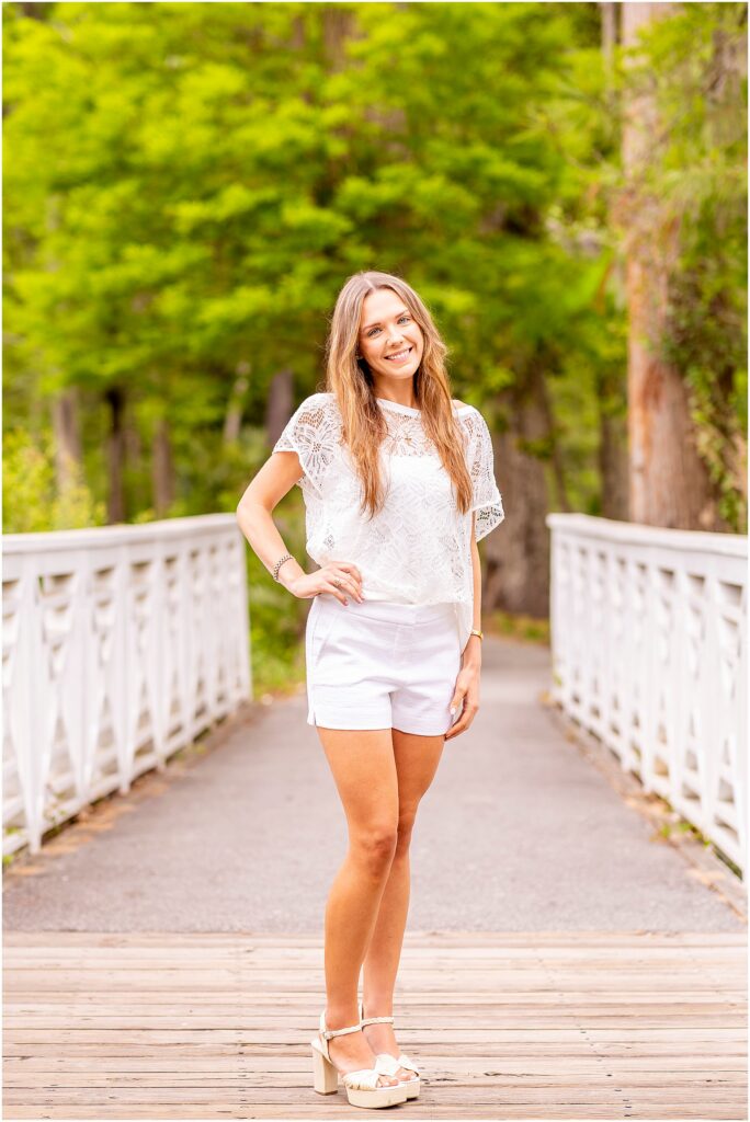 Graduate standing on the famous wooden bridge at Cypress Gardens during a Charleston senior photo session