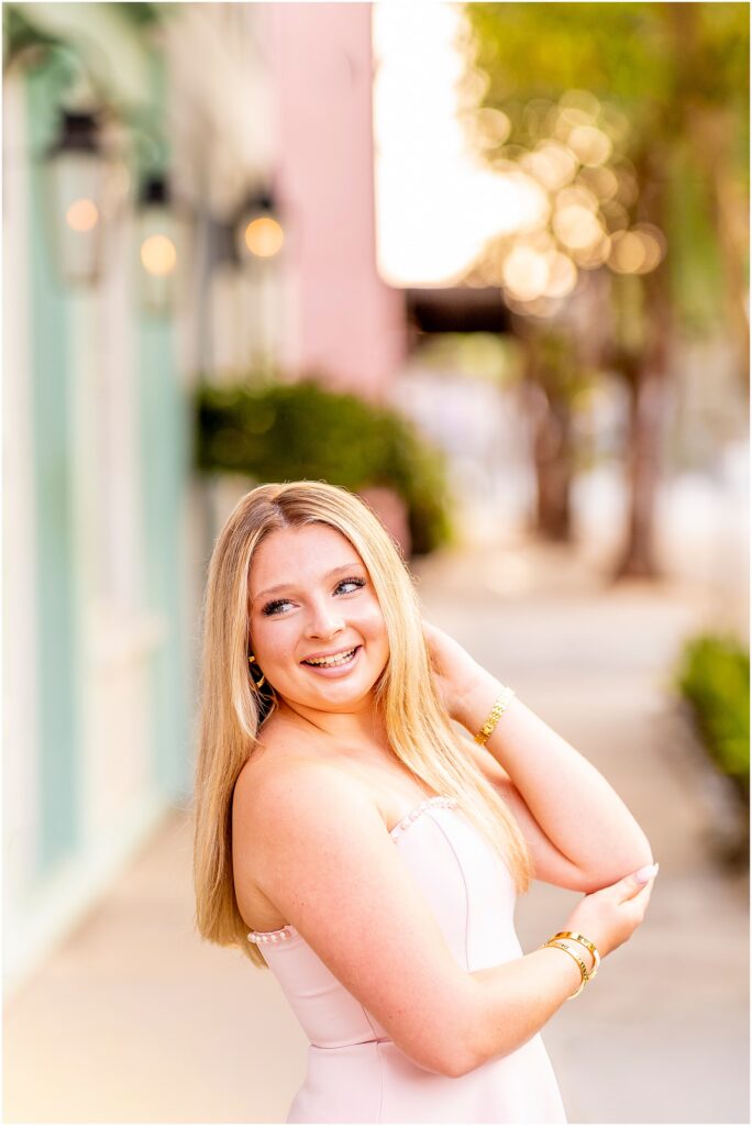 Charleston senior portraits featuring a high school senior smiling along historic Rainbow Row in downtown Charleston.