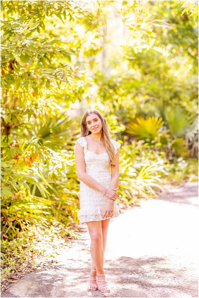 Senior portrait surrounded by towering trees and lush greenery during a Charleston destination senior session.