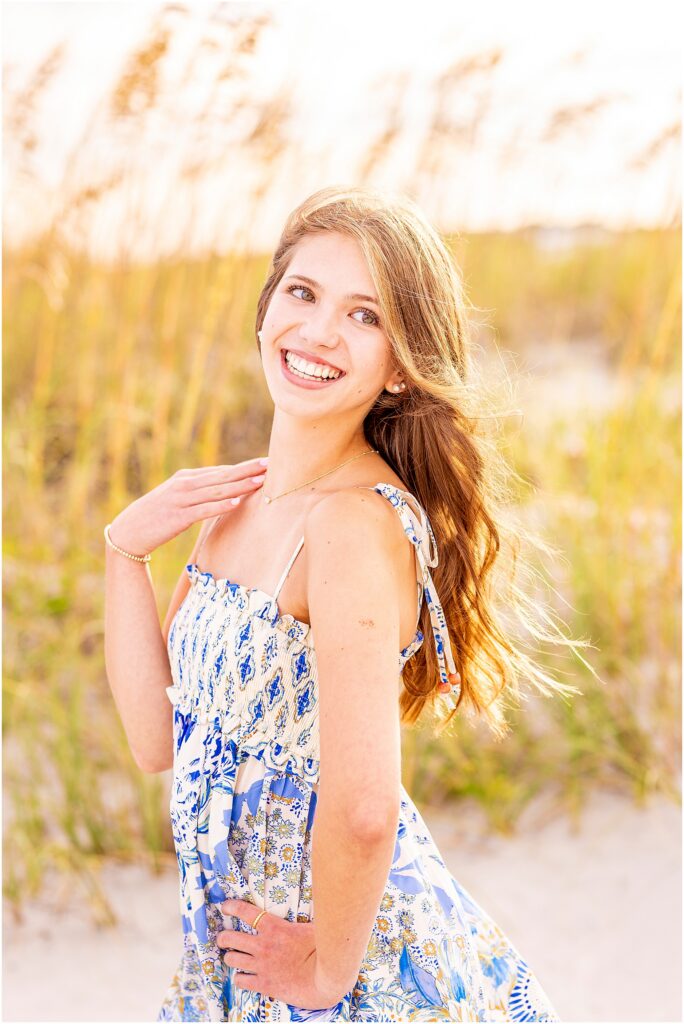 High school senior posing on Isle of Palms Beach during a golden hour senior photography session near Charleston, South Carolina