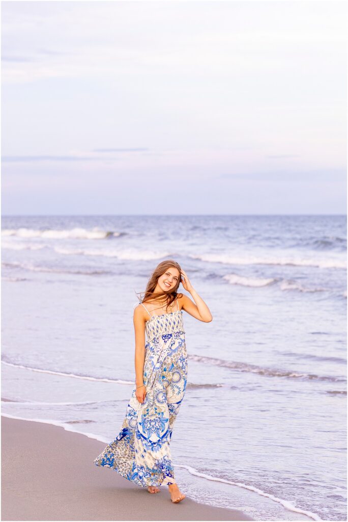 Golden hour senior photos of a high school senior on Isle of Palms Beach with colorful sunset skies and ocean waves in the background