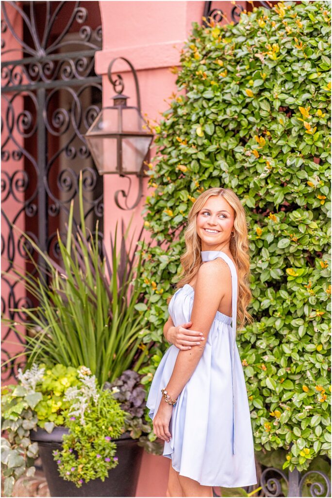 Charleston senior portrait featuring a graduate in a light blue dress along the colorful homes of Rainbow Row