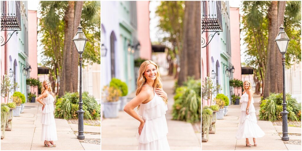 High school senior in a white dress posing on Rainbow Row in historic downtown Charleston