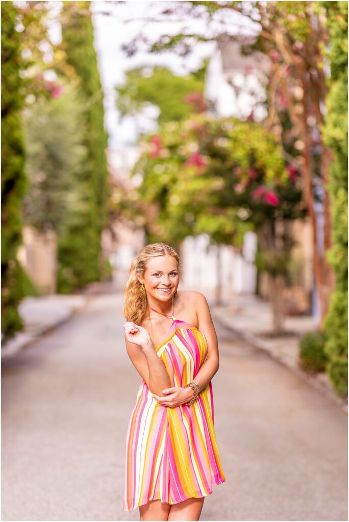 High school senior in a colorful dress posing on Tradd Street in historic downtown Charleston