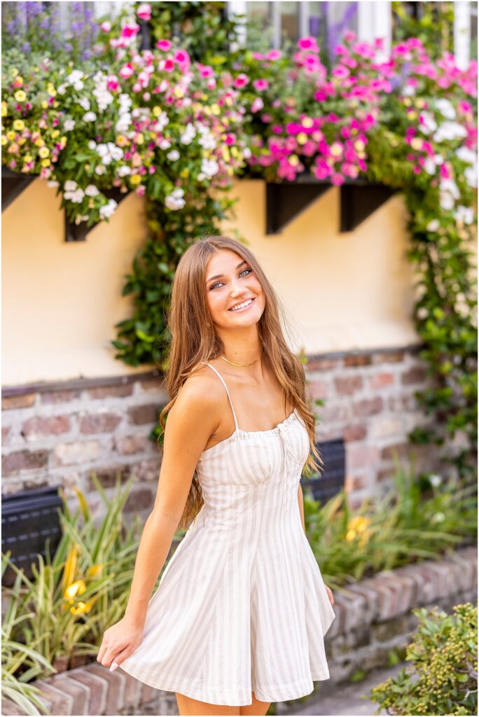 High school senior smiling while walking through the historic cobblestone streets of downtown Charleston