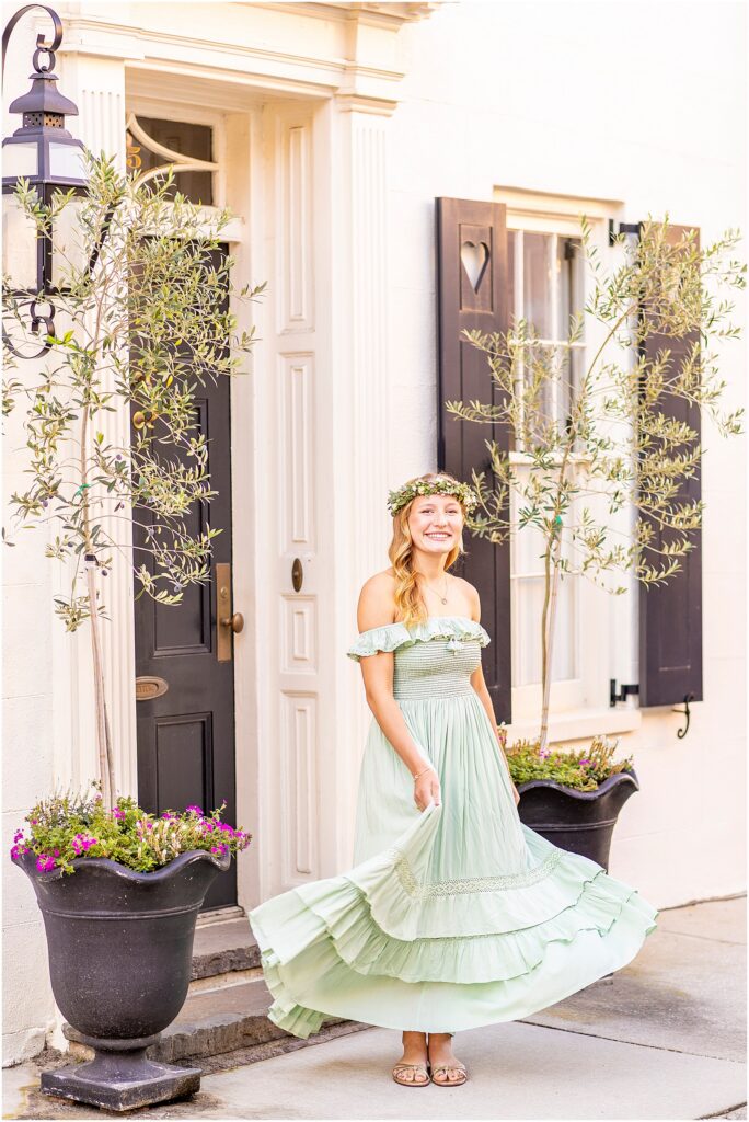 Charleston senior portrait of Ellie in a beautiful green dress and flower crown on the historic streets of South of Broad
